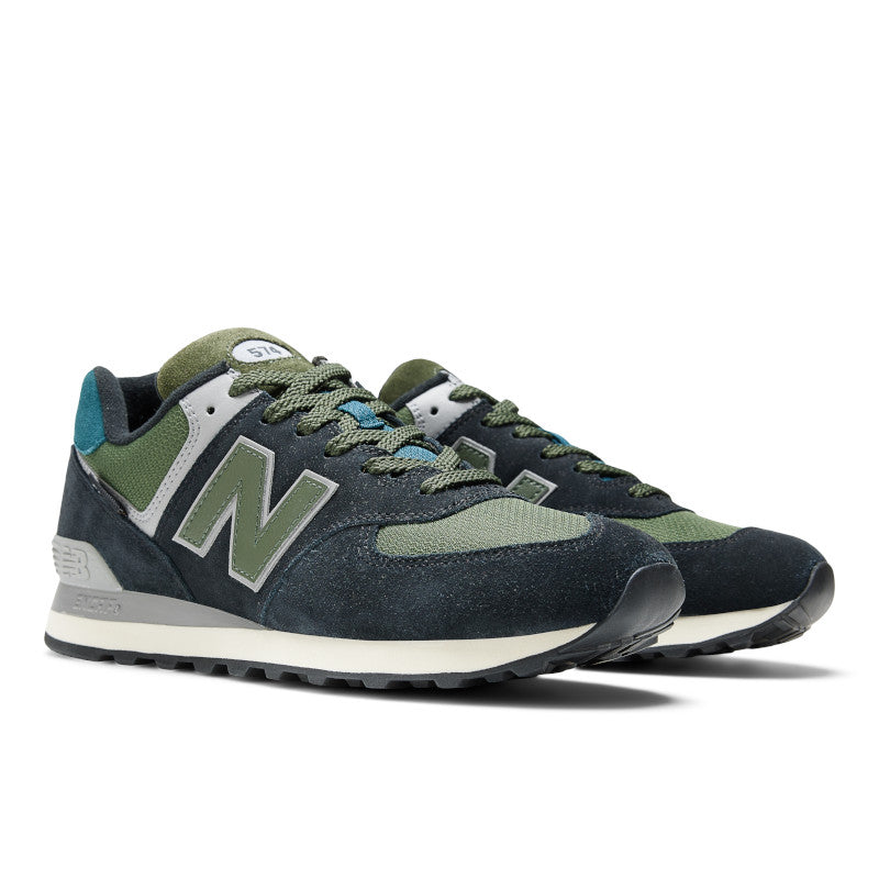 The diagonal view of these New Balane 574's have a dark grey upper with a green/brown lace.  They look really good
