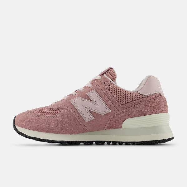 The medial side of a muted pink lifestyle shoe and a white N Cap.