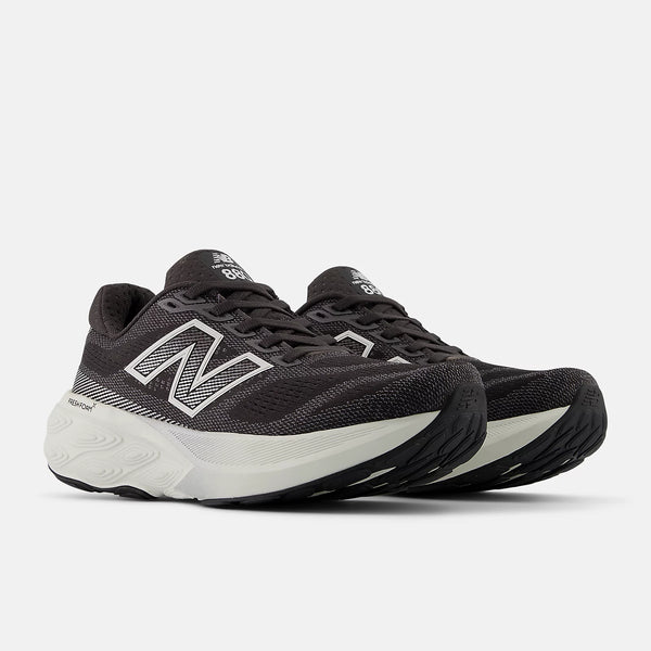 Black running shoes with white soles on a light gray background