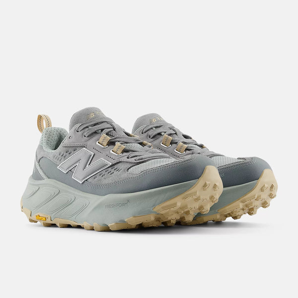 Gray hiking shoes with tan soles on a white background