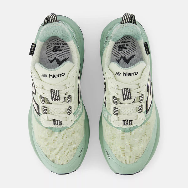 Pair of green and white sneakers with 'hierro' branding on a white background