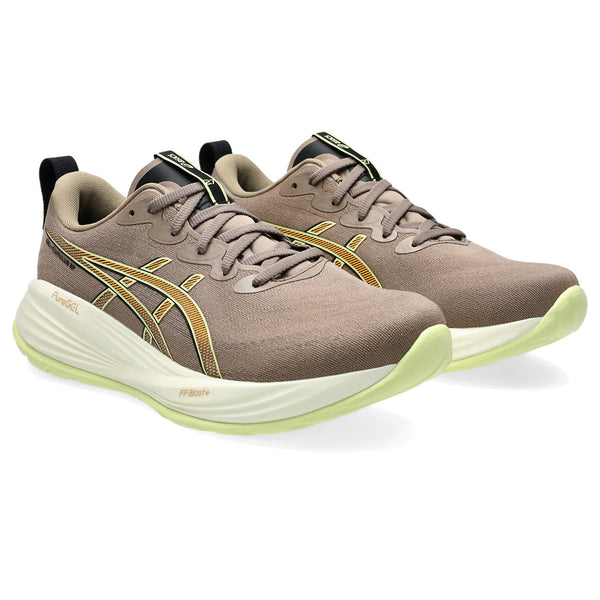 Pair of brown running shoes with green soles on a white background