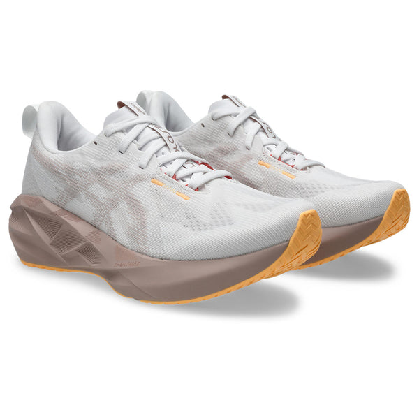 White ASICS running shoes with brown soles on a white background.