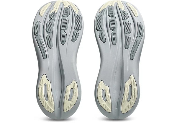 Close-up of a pair of gray athletic shoes with sole details on a white background