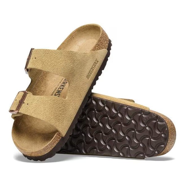 The outsole of this shoe is dark brown and has a geometric pattern. Birkenstock is stamped into the suede upper on the medial side. 