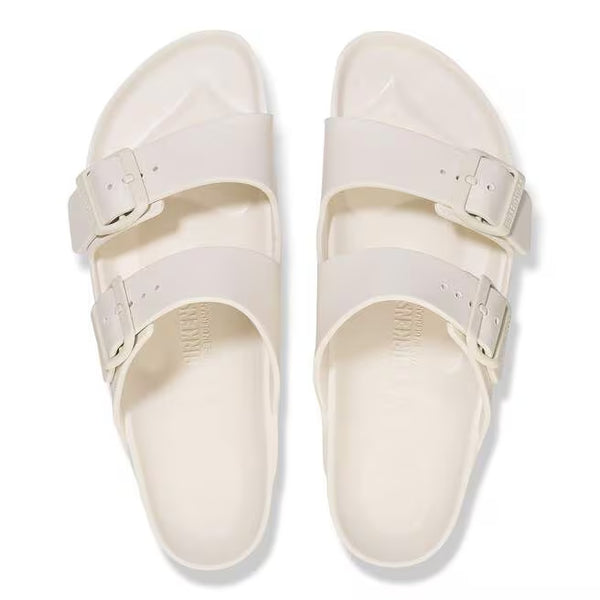 The buckles on the straps of this sandal are off-white and the sole of the shoe has Birkenstock printed vertically. 