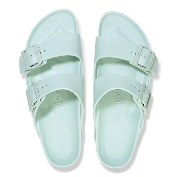 The buckles on the straps of this sandal are seafoam green and the sole of the shoe has Birkenstock printed vertically. 