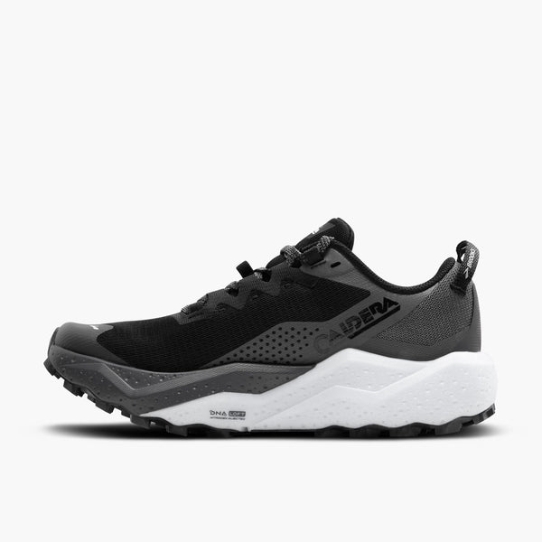The medial side of a black running shoe with white sole on a light gray background.