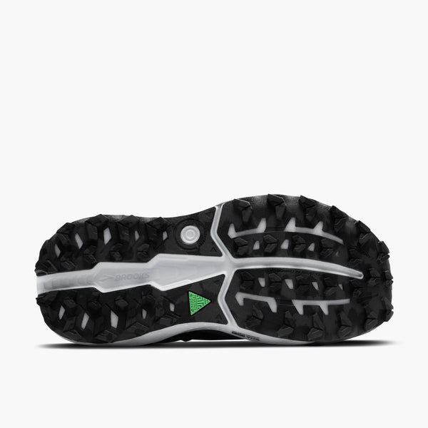 Close-up of a black and white shoe sole with a green logo on a white background.