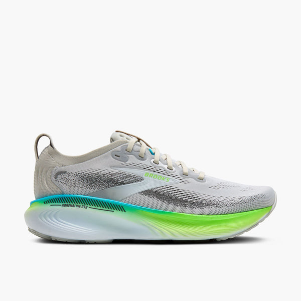 Gray running shoe pops of green in the upper along with green sole on a white background