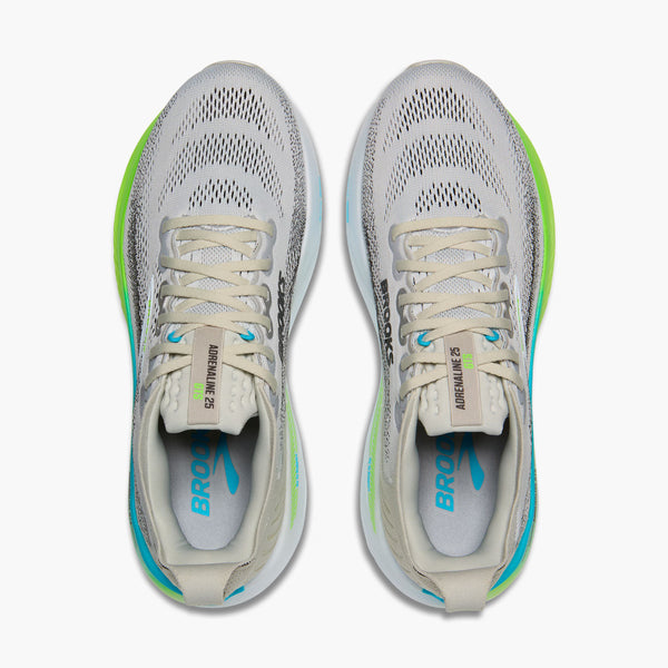 Pair of men's brooks running shoes with green accents on a white background