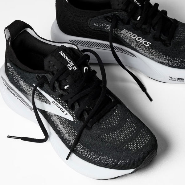 Black running shoe with white sole on a white background