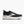 Black running shoe with white sole on a light gray background
