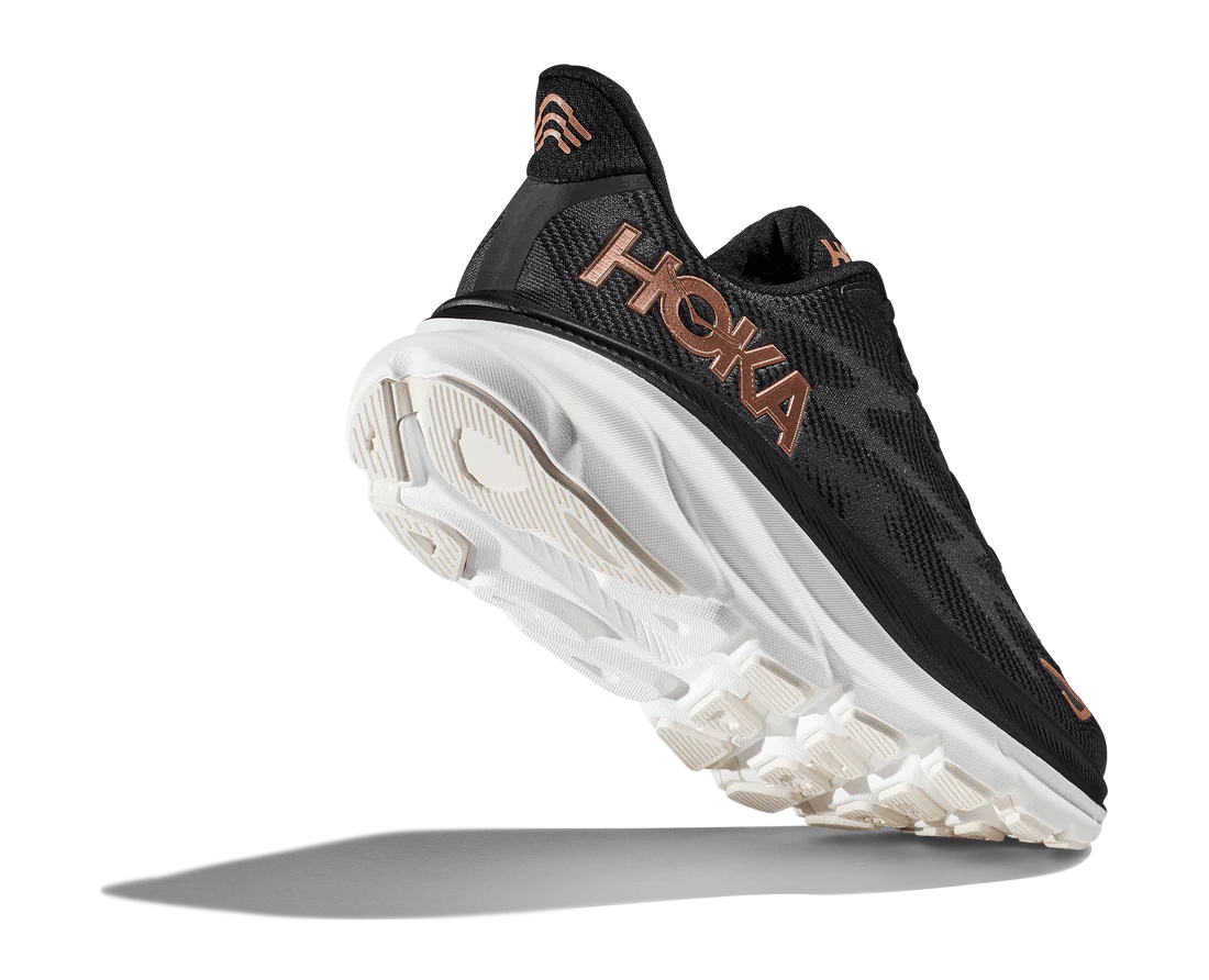 Back angle view of the Women's Clifton 9 by HOKA in Black/Copper