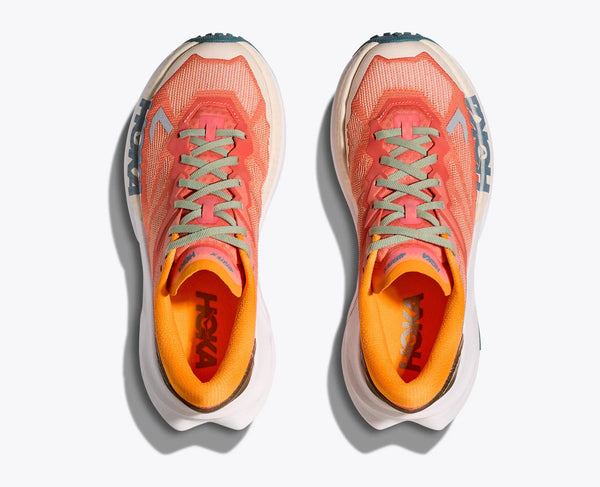 Pair of orange trail running shoes with visible Hoka branding on a white background
