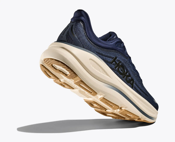 Navy running shoe with beige sole on a white background