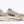 Beige running shoe with 'Hoka' branding on a white background