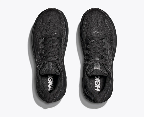 Black athletic shoes with 'HOKA' branding on a white background