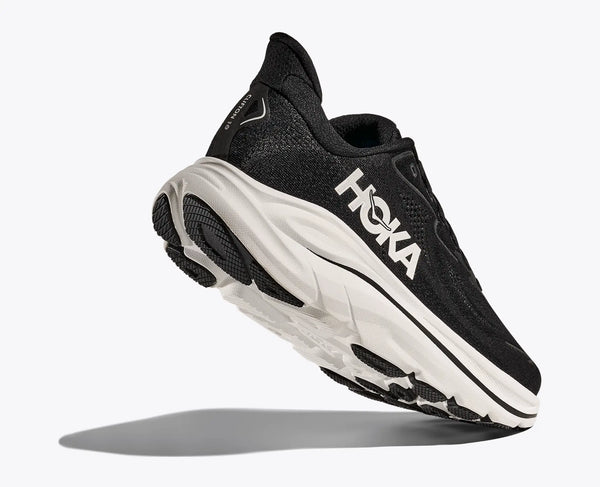 Black running shoe with white sole on a light gray background