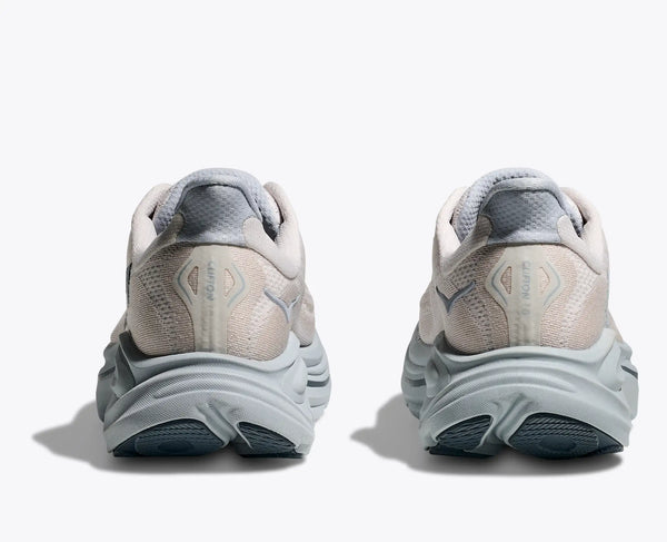 Pair of white and light grey running shoes with gray accents on a grey background.