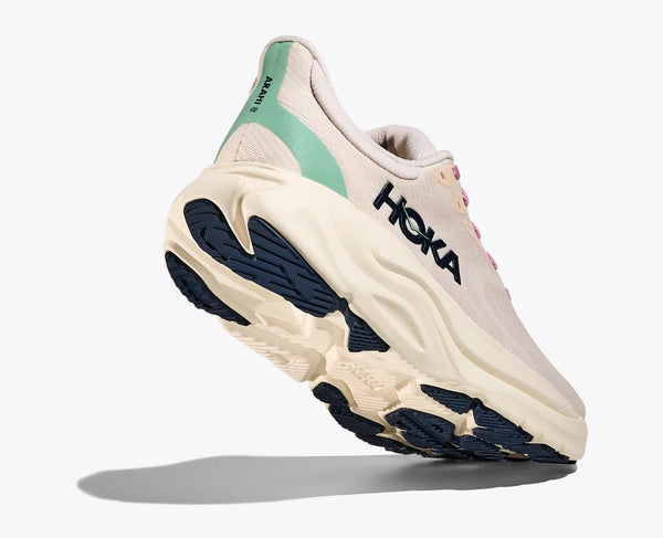 An off-white Hoka running shoe with blue sole on a white background
