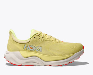 Yellow running shoe with white sole on a light gray background