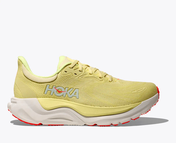 Yellow running shoe with white sole on a light gray background