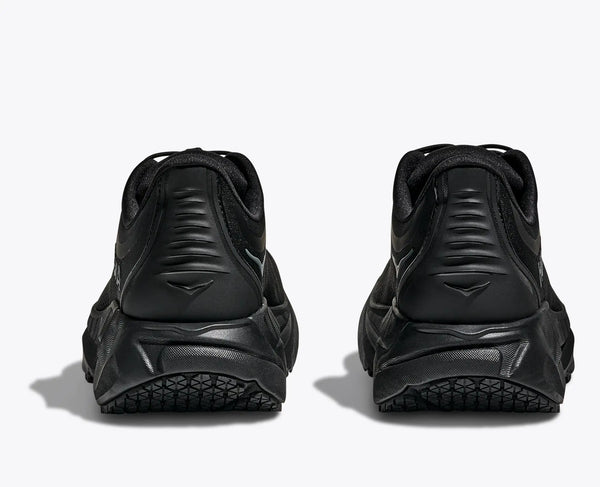 Black athletic shoes shown from the back on a white background