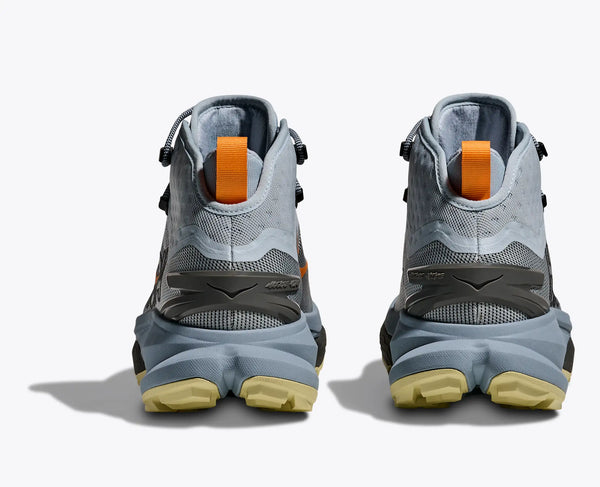 Pair of gray high-top hiking boots with orange accents on a white background
