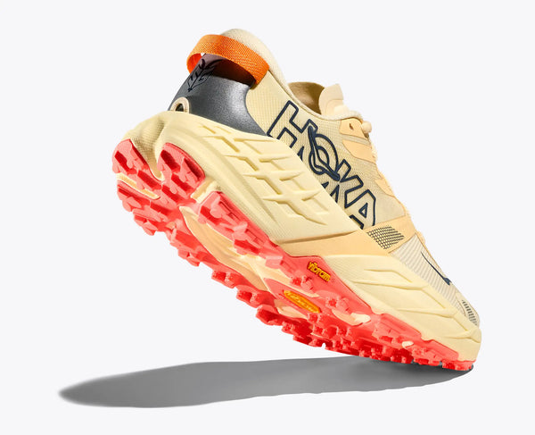 Beige and red running shoe with 'Hoka' branding on a white background