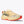 Beige running shoe with red sole on a white background