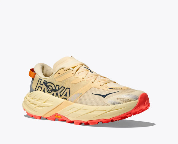 Beige running shoe with red sole on a white background