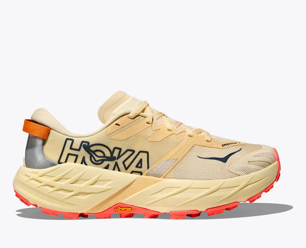 Light butter colored running shoe with red accents on a white background