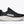 Black running shoe with white sole on a light gray background