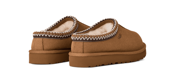 Brown Ugg slipers with decorative trim on a transparent background.