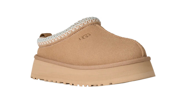 Tan UGG slipper on a white background