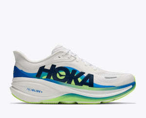 A Hoka running shoe in white with navy, blue, and lime green accents, shown in a side profile on a light gray background.