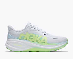 White running shoe with green sole and 'Hoka' branding on a white background