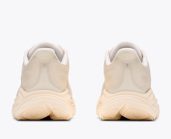 Pair of beige running shoes shown from the back on a white background