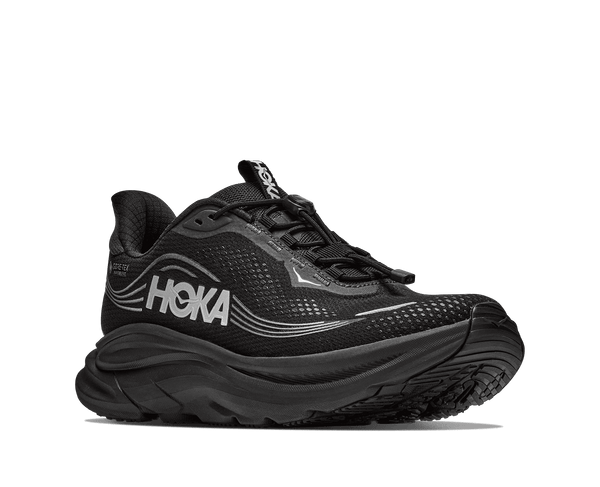 A black running shoe with a thick black sole and silver wavy stripe accents on the side,