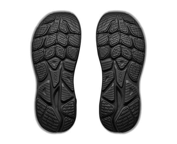 A black running shoe with a thick black sole and silver wavy stripe accents on the side,