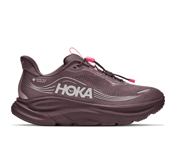A HOKA running shoe in a muted plum-purple color with bright pink laces and pull tabs