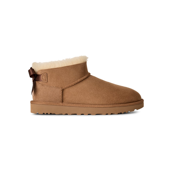 Tan ankle length slipper boot with a bow on the back