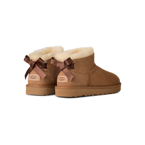 Tan ankle length slipper boot with a bow on the back