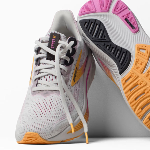 White athletic shoe with pink and orange accents on a white background