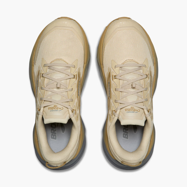 Pair of beige sneakers with visible branding on a white background