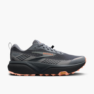 Brooks trail running shoe in dark gray and black with a coral pink outsole, shown from a three-quarters angle on a light gray background.