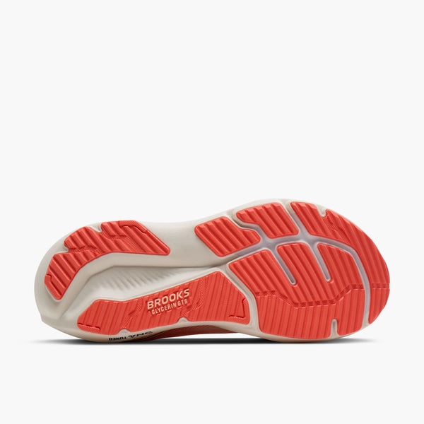 Sole of a running shoe with red tread pattern on a white background