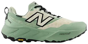 New Balance trail running shoe in mint green and cream with black accents, featuring the signature 'N' logo on the side, Vibram sole, and FreshFoam technology.