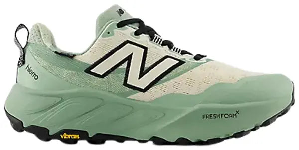 New Balance trail running shoe in mint green and cream with black accents, featuring the signature 'N' logo on the side, Vibram sole, and FreshFoam technology.
